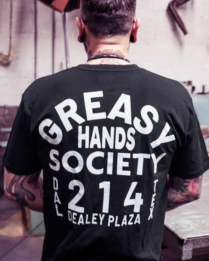 Person wearing a black t-shirt with 'Greasy Hands Society' dealey plaza text on the back.