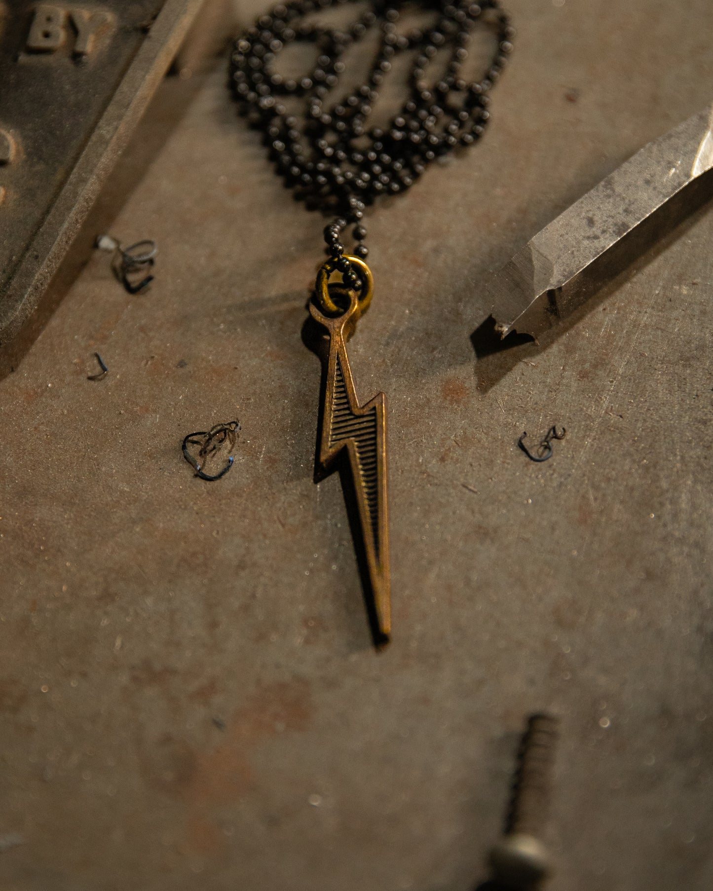 lightning bolt brass pendant on black ball chain