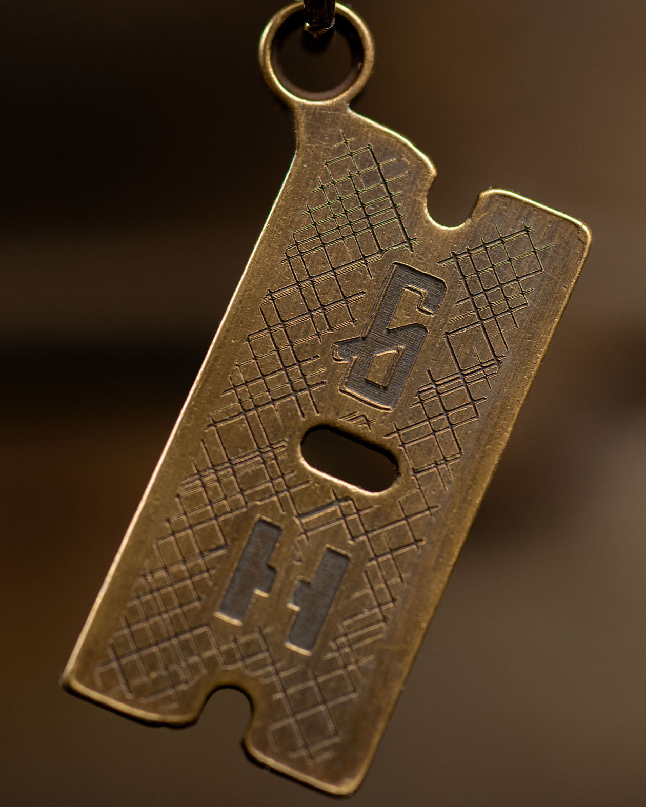 RZR razor blade design brass necklace - showing the back side of the razorblade with the greasy hands society G