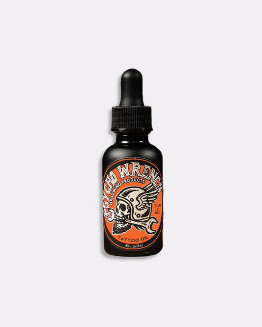 Black bottle of Psycho Wrench beard oil with orange label on a white background - Psycho Wrench Tap & Die Tattoo Oil by Greasy Hands Society