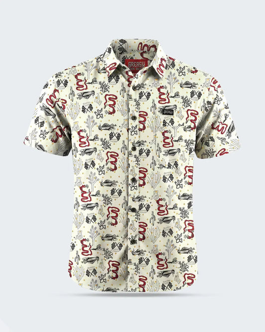 A short-sleeve button-up shirt with an all-over abstract pattern in red, black, and gray on a warm off-white background, shown against a light gray studio backdrop - Baja Button-Up Shirt by Greasy Hands Society