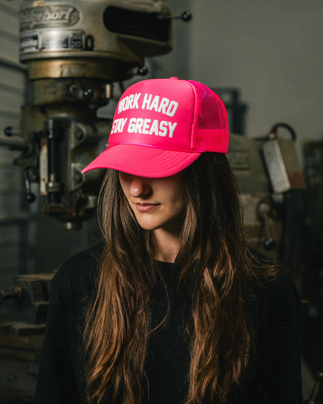 women's neon pink trucker hat with work hard stay greasy on the front