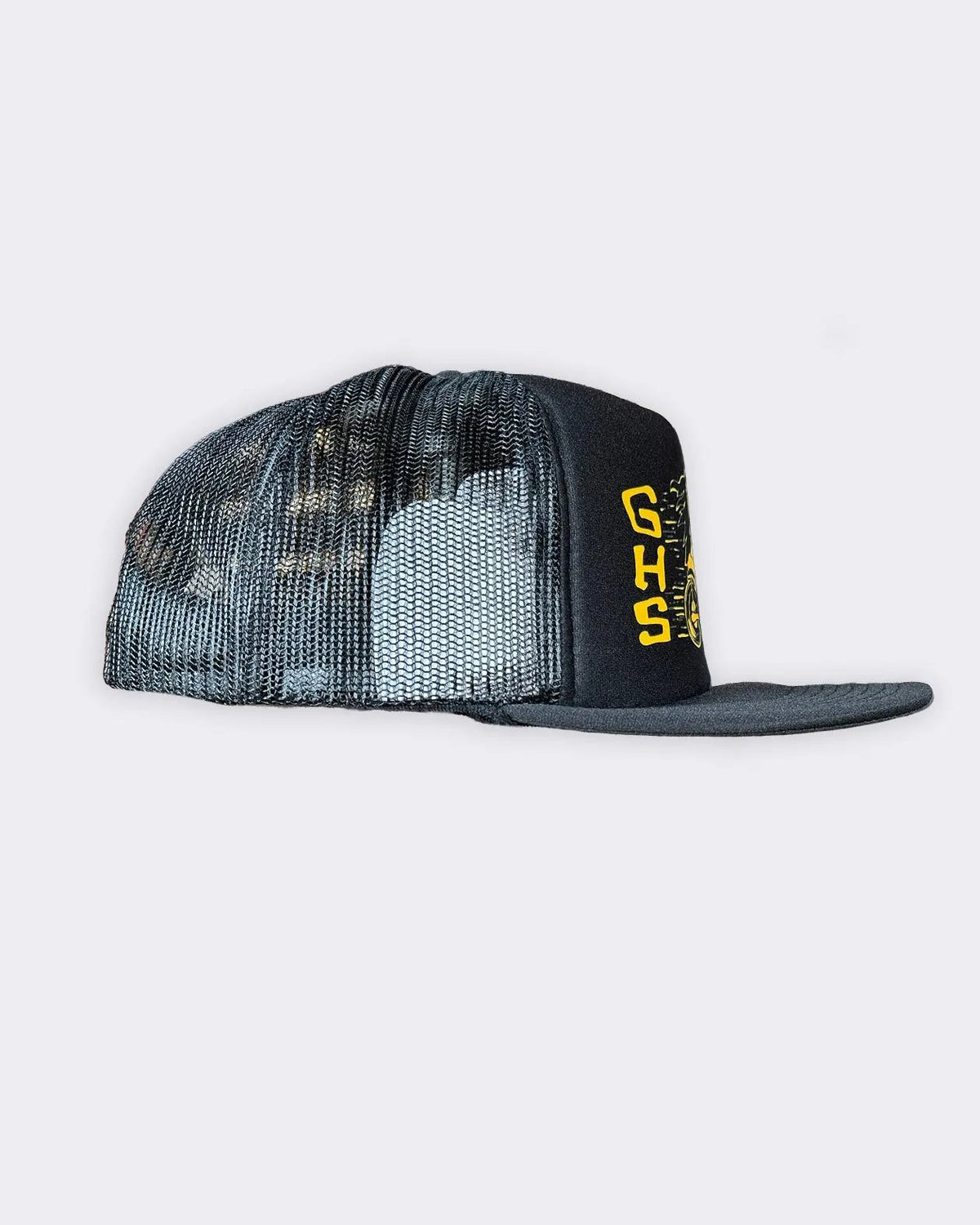 A black trucker hat with a black and gray camouflage mesh back and a black flat brim featuring yellow 'GHS' lettering on the side, set against a light gray background - Degenerates Hat by Greasy Hands Society