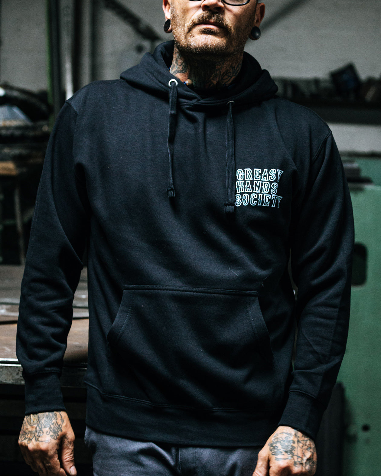 Eat Dust Hoodieworn by a model a black hoodie showing greasy hands society on the left chest