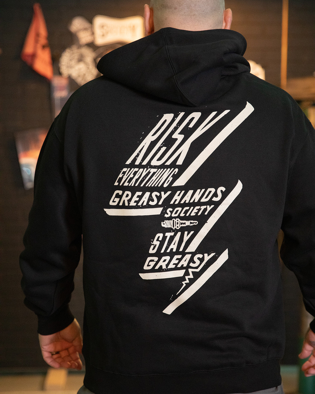 bolted down black heavyweight hoodie full back graphic of a lightning bolt saying risk everything greasy hands society stay greasy