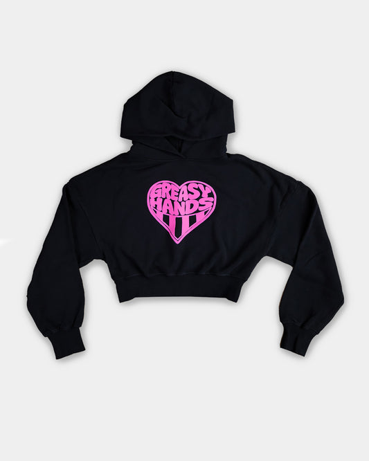 Black crop top hoodie with pink heart design on a light gray background