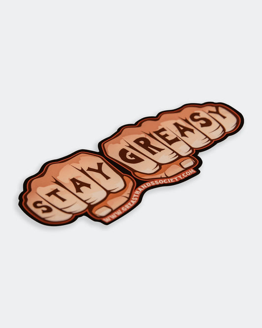 Knuckles Sticker orange sticker with tattooed knuckles showin stay greasy flat lay at an angle