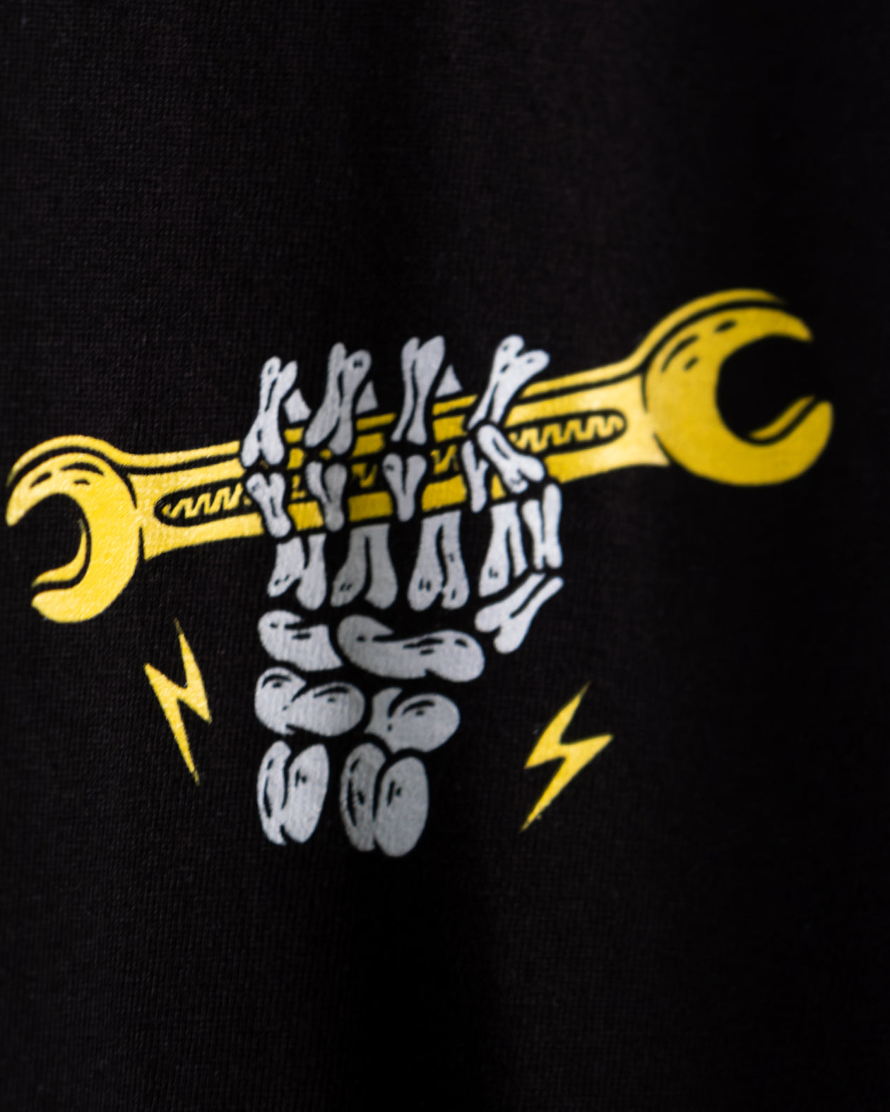 front left chest graphic of a skeleton holding a wrench - Built for Pride men's black graphic t-shirt by greasy hands society