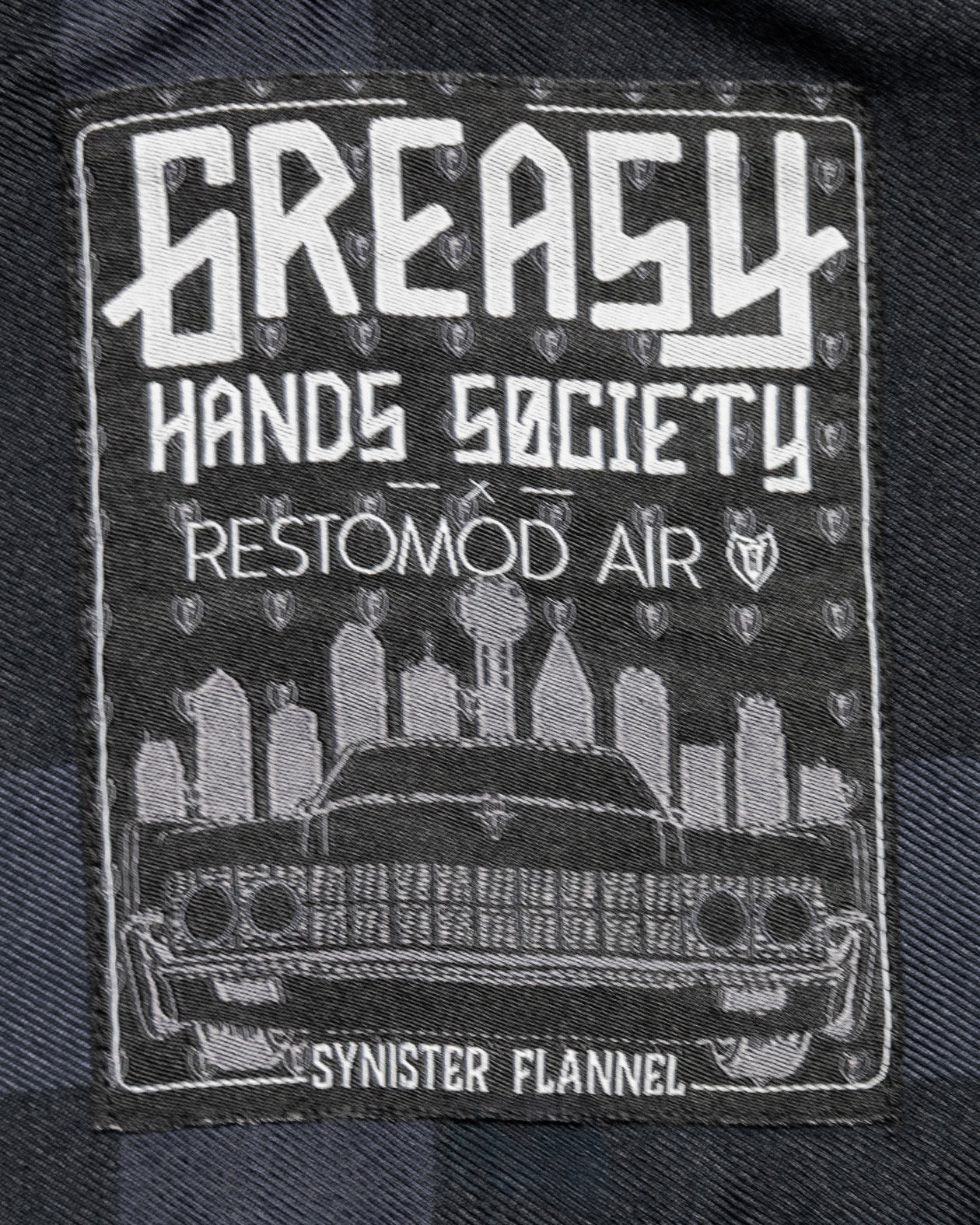 greasy hands society Synister flannel label detail showing the Dallas skyline and a black Lincoln continental