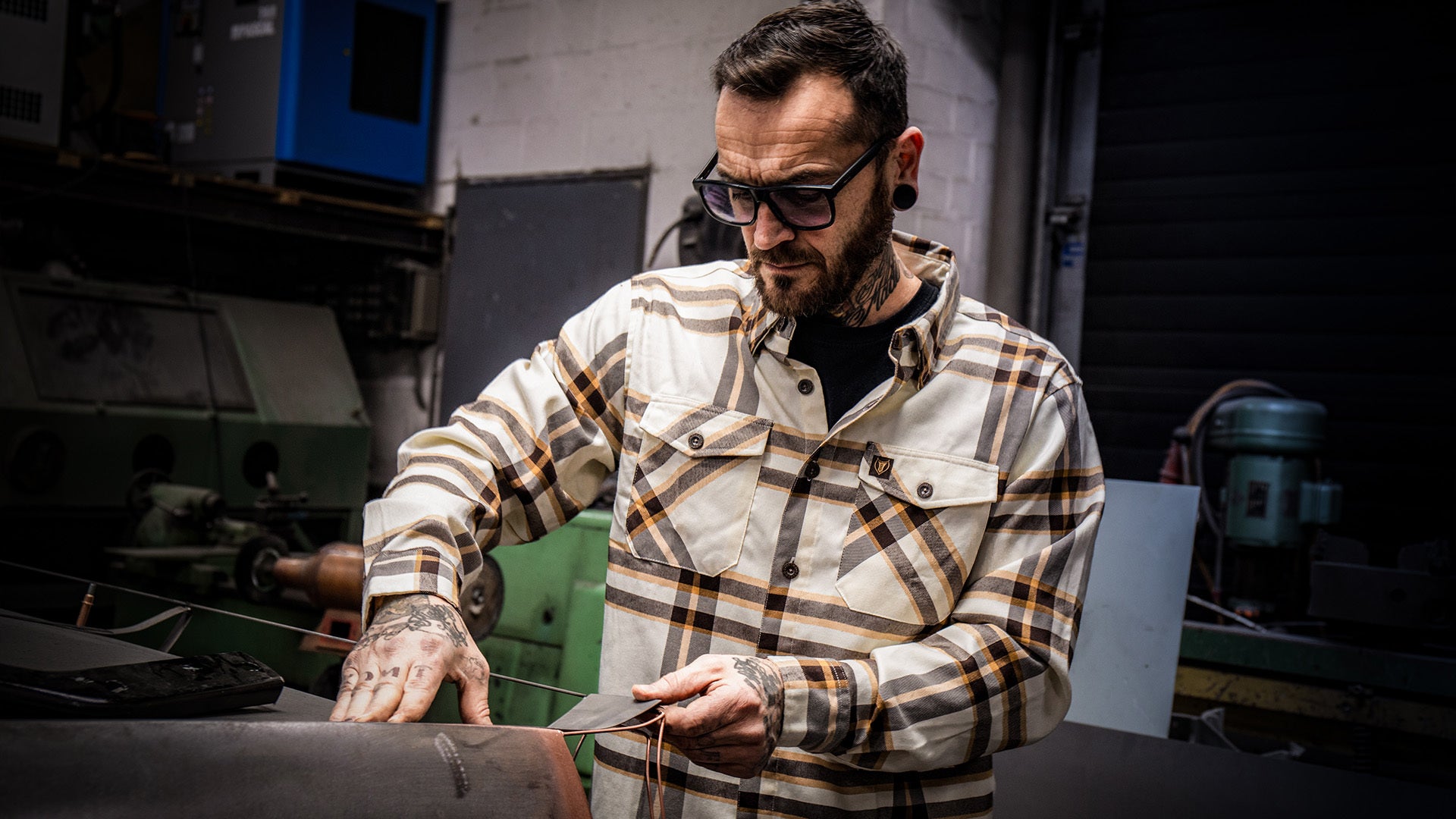 whiskey flannel in tan gold and brown plaid pattern work by a guy working with his hands