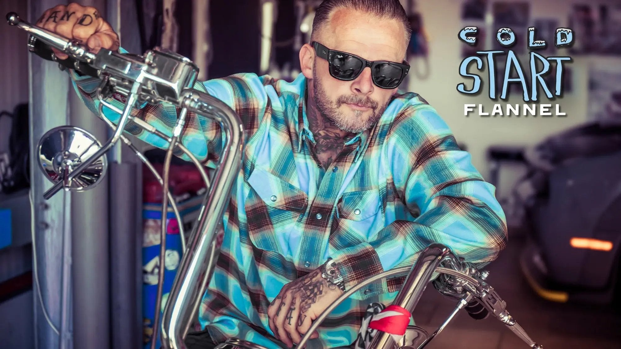 man wearing sunglasses wearing a blue, brown and white flannel shirt while riding a motorcycle with the promotional text "Cold Start Flannel"  - Cold Start Flannel by Greasy Hands Society