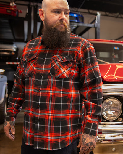 the detour flannel in red, black and white being worn at a car showroom