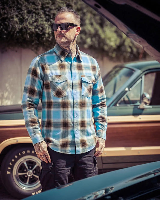 Man wearing a plaid blue and brown flannel shirt and sunglasses standing next to a vintage truck - Cold Start Flannel by Greasy Hands Society