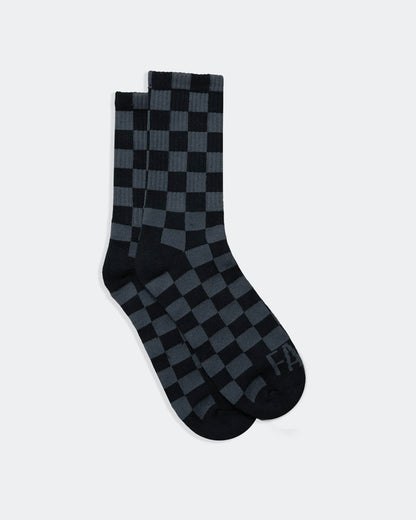 Black and gray checkered socks on a white background from greasy hands society