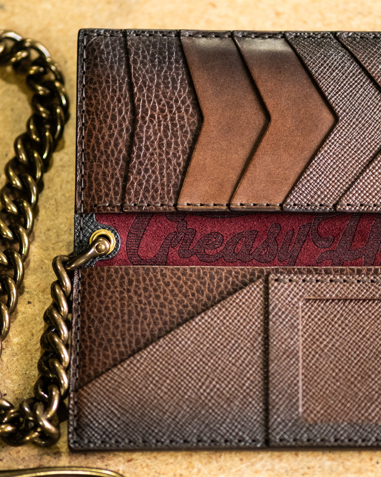 Brown leather wallet with chain on a textured surface
