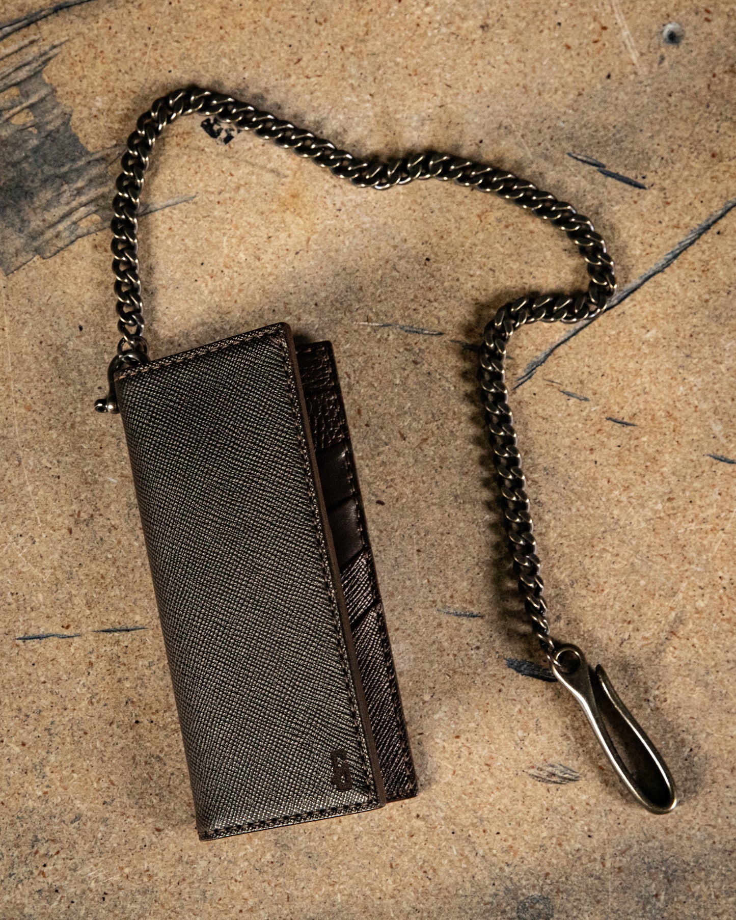 brown vertical leather wallet with brass chain