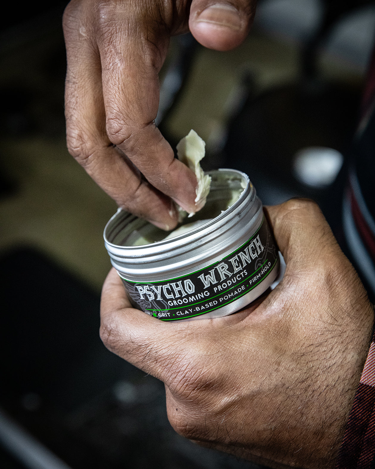 person using psycho wrench clay-based pomade - getting it in their hands
