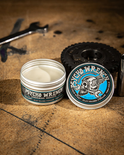 Jar of Psycho Wrench grooming product on a textured surface with tools in the background