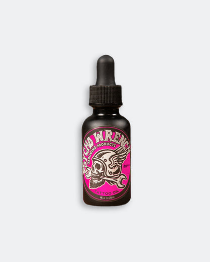 Bottle of smooth idle tattoo oil with pink label on a white background