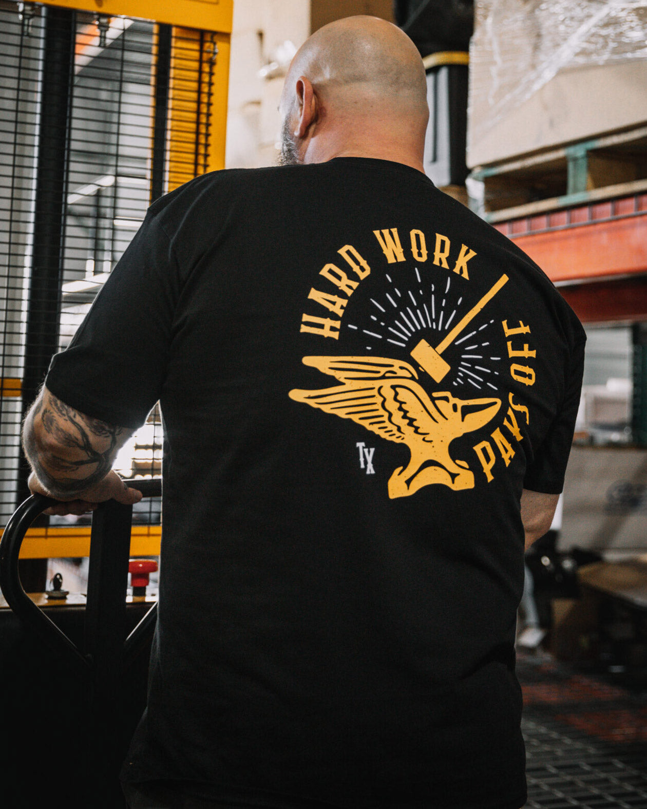 hard work pays off black graphic tee showing a hammer and winged anvil