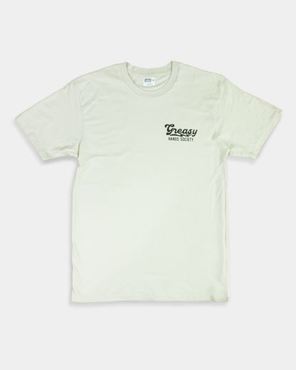 Light beige women's graphic tee t-shirt with 'Greasy' logo on a white background showing the front side with left chest graphic