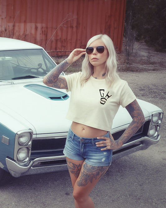 women's well balanced grpahic crop top t-shirt - Woman posing in front of a classic car wearing a crop top with a logo and denim shorts - Well Balanced Crop Top by Greasy Hands Society