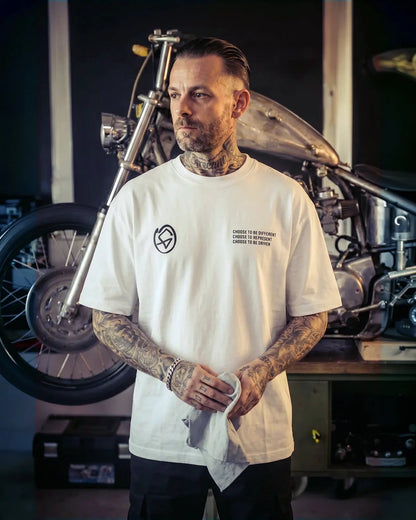 Man with tattoos wearing a white t-shirt in a garage with a motorcycle. - Tailgate Boxy White Heavyweight graphic Tee by Greasy Hands Society