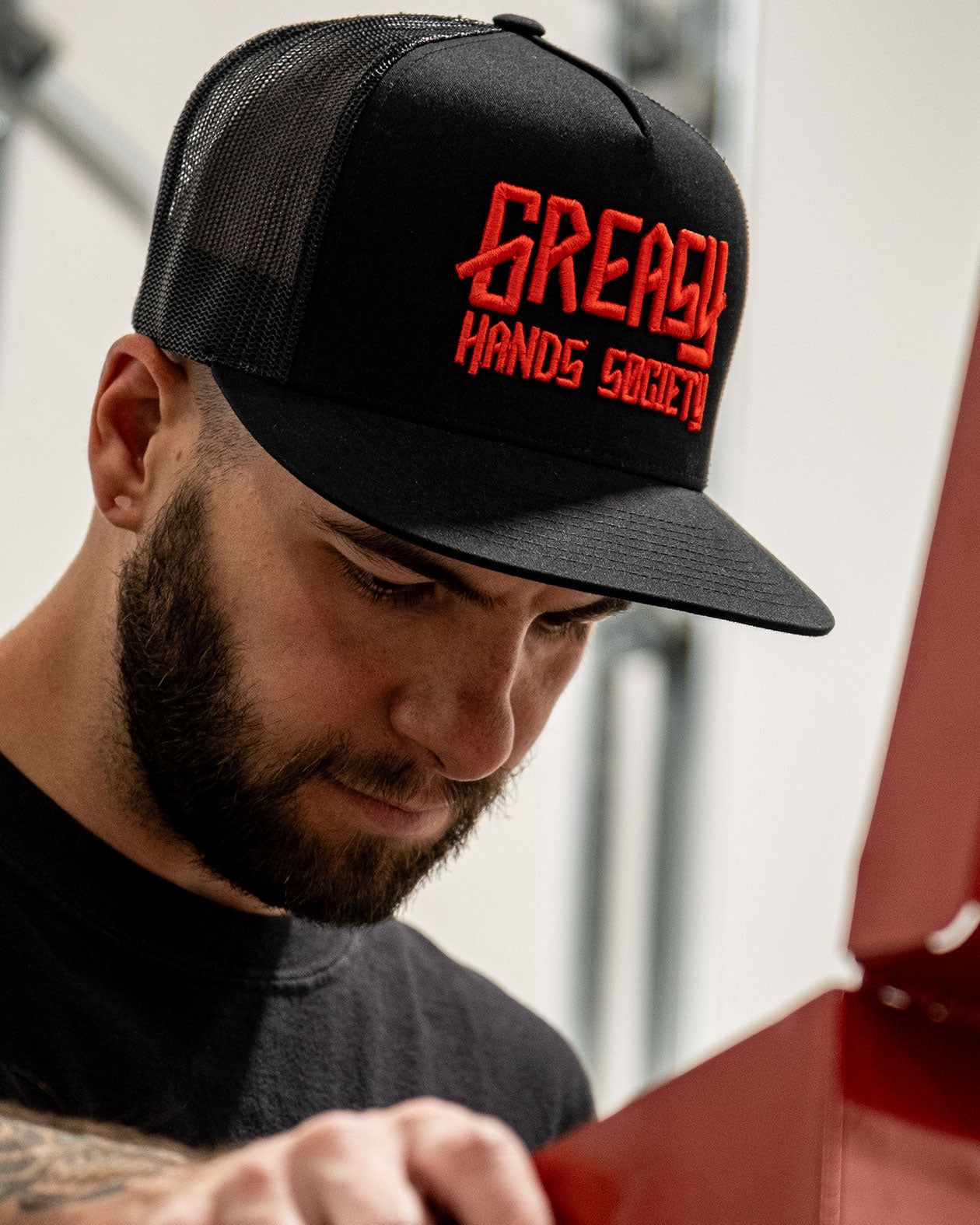 black snapback hat with red logo on a model