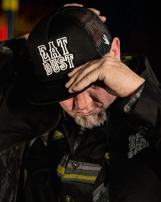 black cap with white eat dust text tucker hat