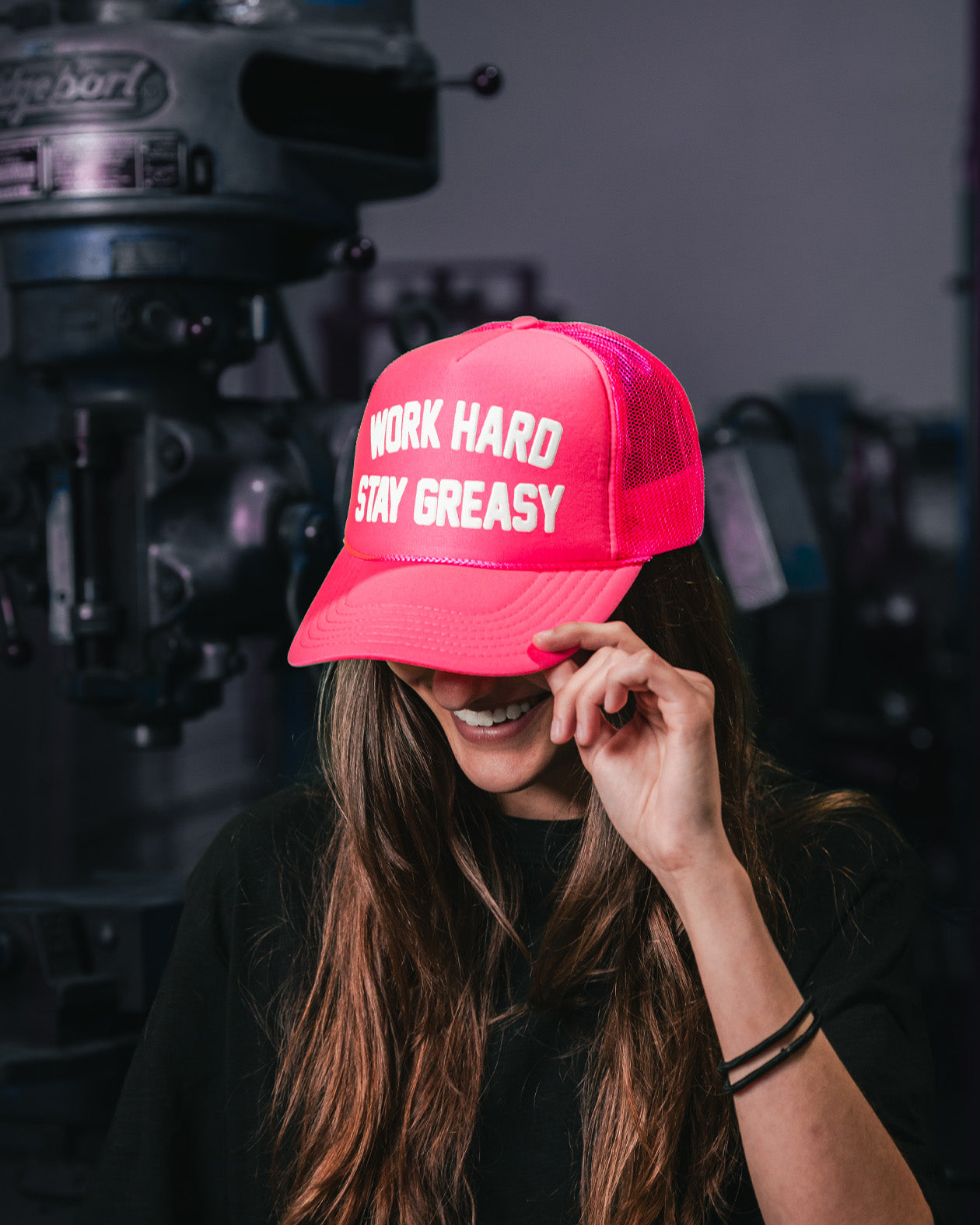 women's neon pink trucker hat with work hard stay greasy on the front