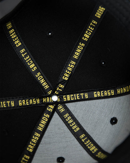 interior of a Black cap with yellow text on a dark background