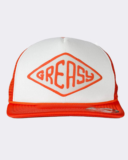 A white and orange trucker hat featuring a large orange diamond logo with the word 'GREASY' on the front panel, set against a light gray background - Cross the Line Orange/White Hat by Greasy Hands Society