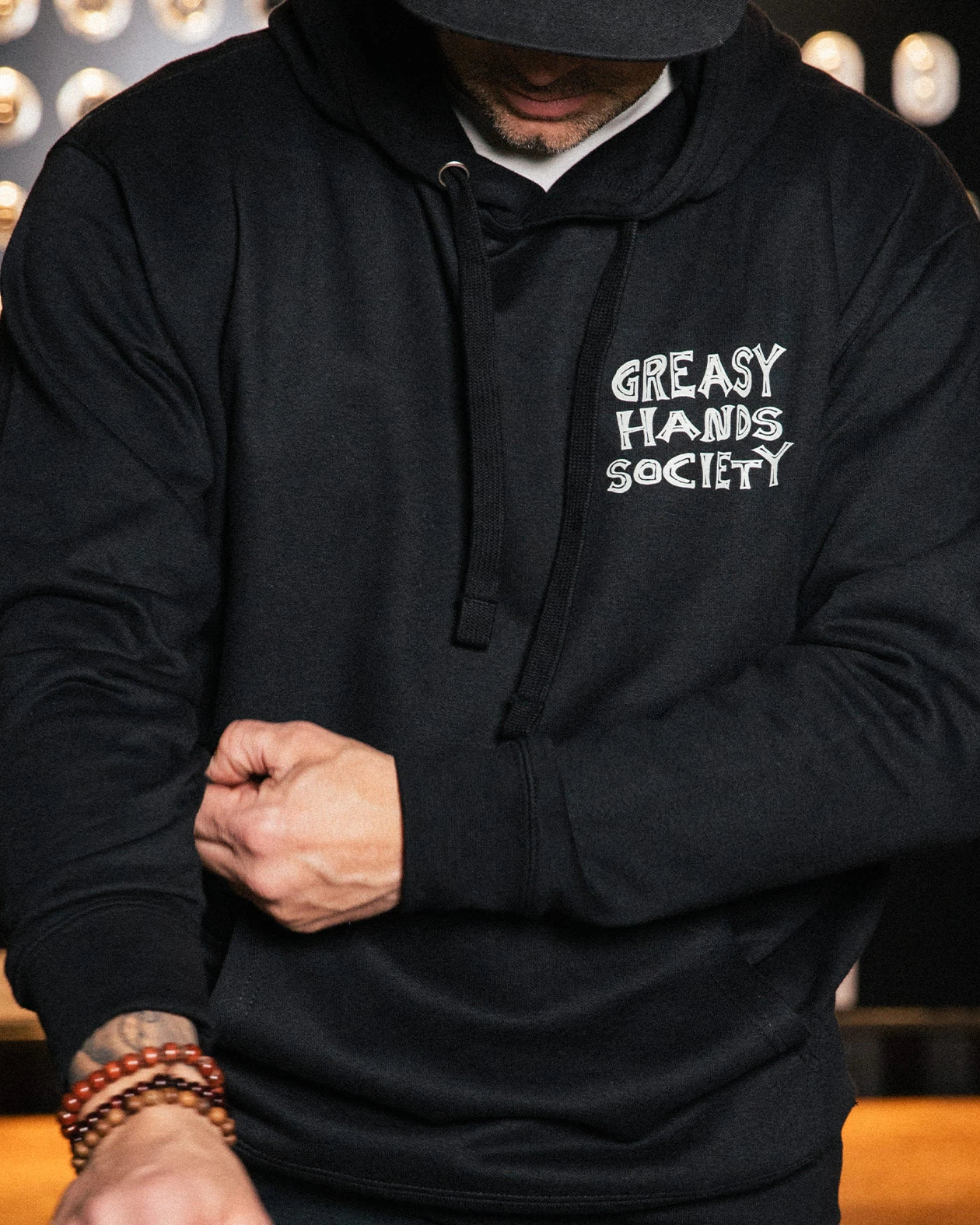 black Live Fast Stay Greasy Hoodie front view on a model showing front left chest 