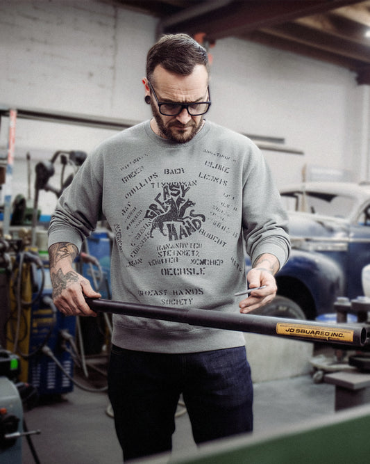 man wearing the navy dogs gray sweatshirt from greasy hands society