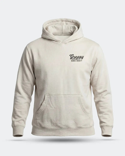 A light beige pullover hoodie with a small black 'Greasy Hands Society' logo on the left chest, displayed on a clean light gray background - Men's Destination Hoodie by Greasy Hands Society
