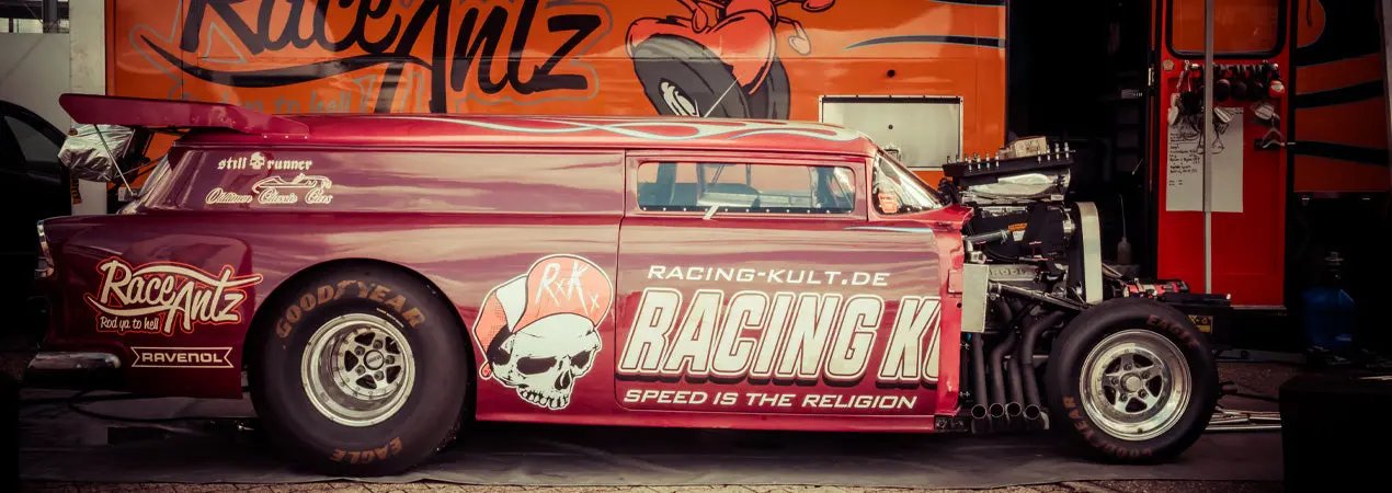 Red racing truck with 'Racing K' branding in a garage setting