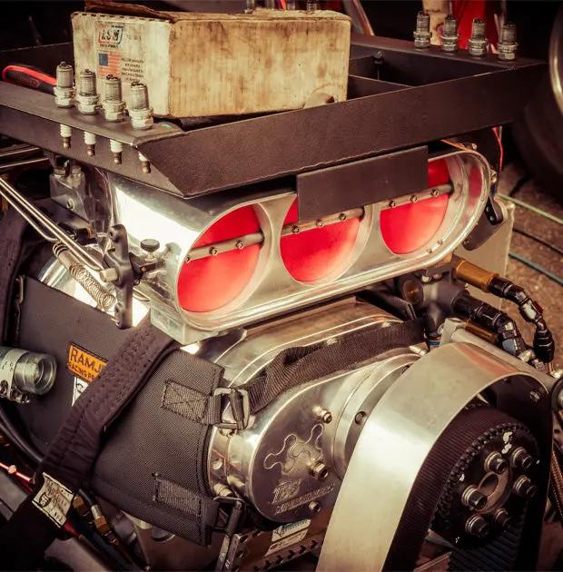 Close-up of a high-performance engine with red valve covers and visible branding.