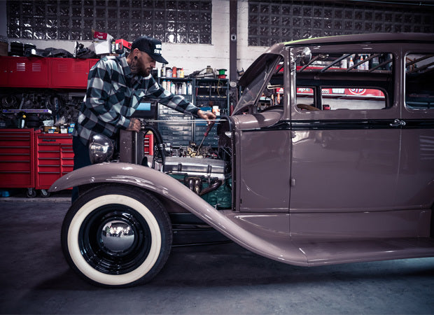 Man working on a vintage car in a garage - The Banger Flannel by Greasy Hands Society