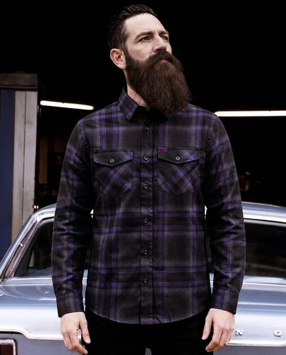 Man wearing a black and purple plaid flannel shirt - purple flannel- standing in front of a car - Kiss the Sky Flannel by Greasy Hands Society