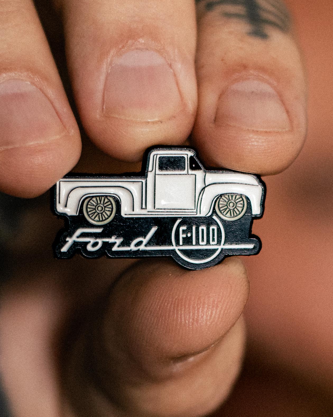 ford f-100 truck pin - enamel pin in black and white held up to show the pin