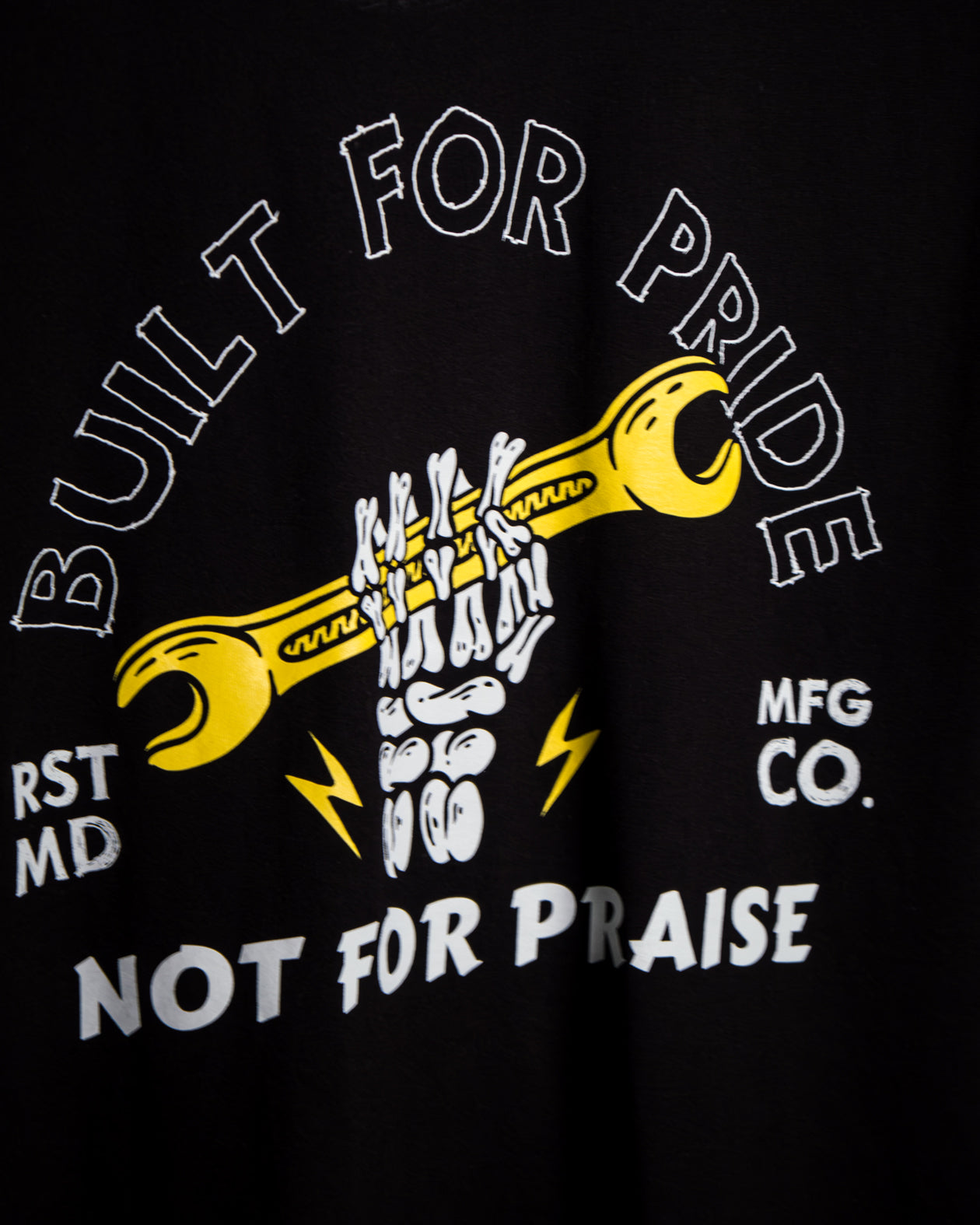 graphic design of a skeleton holding a wrench with the words 'Built for pride, not praise' around the outside - Built for Pride men's black graphic t-shirt by Greasy Hands Society
