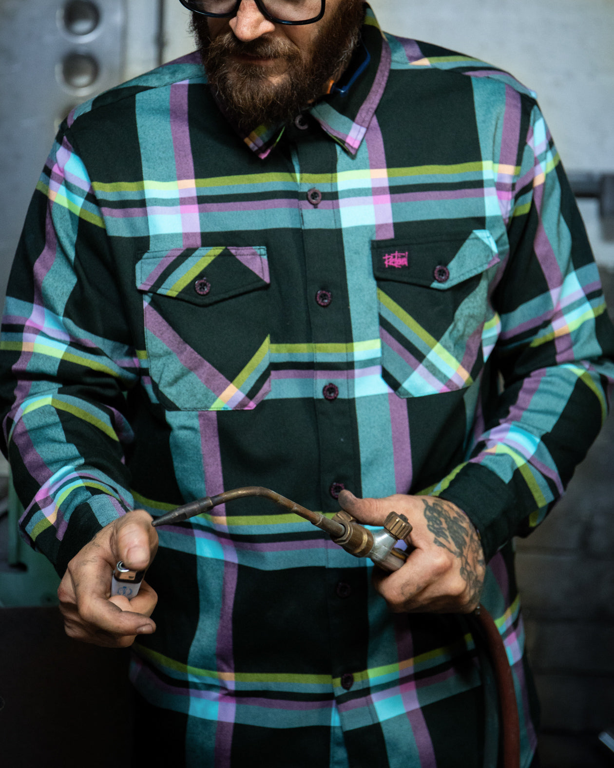 Pinstriper model photo in the blue, pink, yellow, and black pinstriper flannel on a model working with his hands