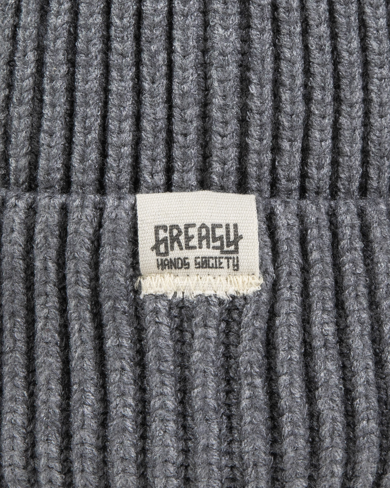 Gray watch cap detail showing the greasy hands society logo tag