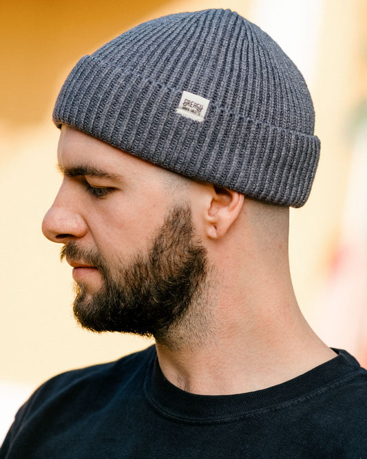 gray watch cap with greasy hands society logo tag on a model