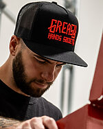 black logo hat with red logo on a model