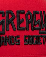 black greasy hands society logo on red hat detail